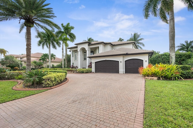 mediterranean / spanish house with a front yard and a garage