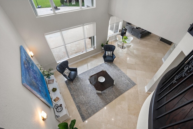 living room featuring a towering ceiling and plenty of natural light