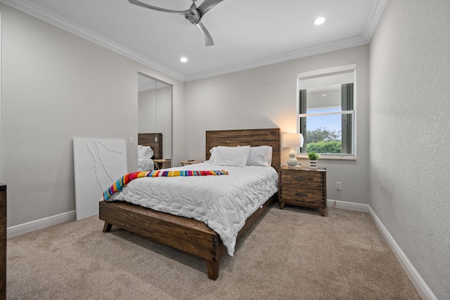 carpeted bedroom featuring ceiling fan, crown molding, and a closet