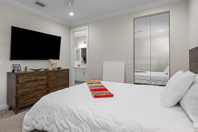 bedroom featuring ensuite bath, carpet flooring, a closet, and ornamental molding