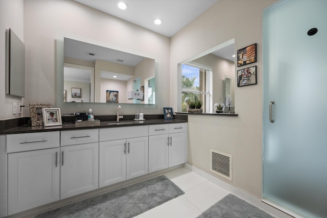 bathroom featuring walk in shower, vanity, and tile patterned floors