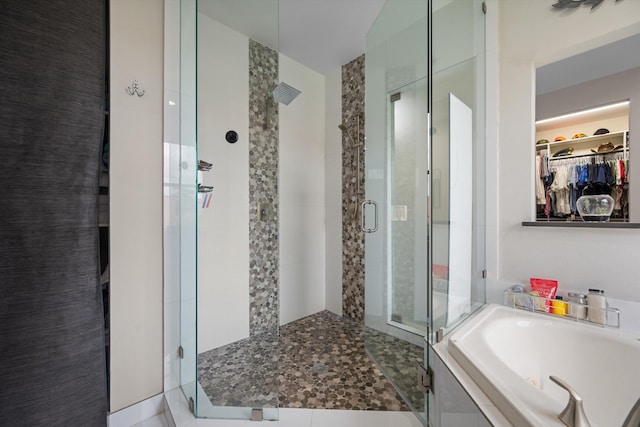 bathroom featuring shower with separate bathtub