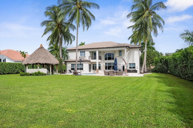 back of property featuring a patio, a lawn, and a gazebo