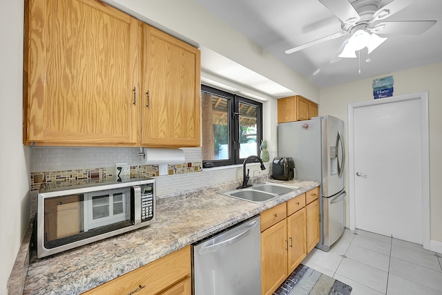 kitchen with tasteful backsplash, stainless steel appliances, light tile patterned floors, sink, and ceiling fan