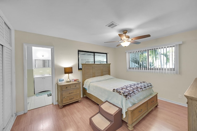 bedroom featuring light hardwood / wood-style floors, ceiling fan, and connected bathroom