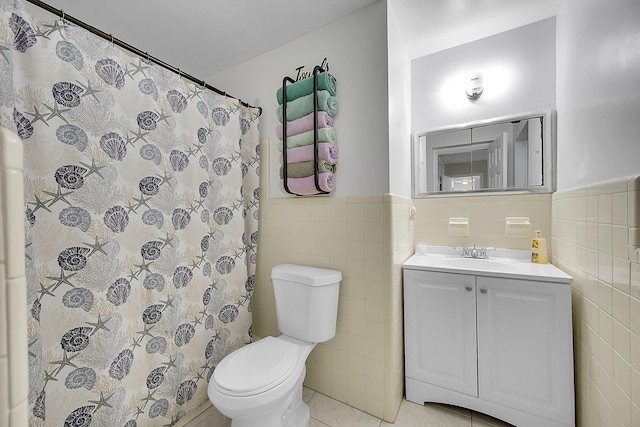 bathroom featuring toilet, vanity, tile walls, and tile patterned flooring