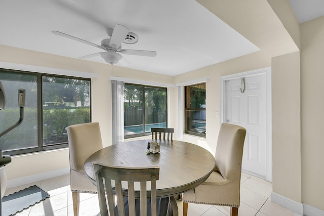 dining area with a wealth of natural light, light tile patterned floors, and ceiling fan