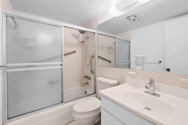 full bathroom with toilet, vanity, shower / bath combination with glass door, and tile walls