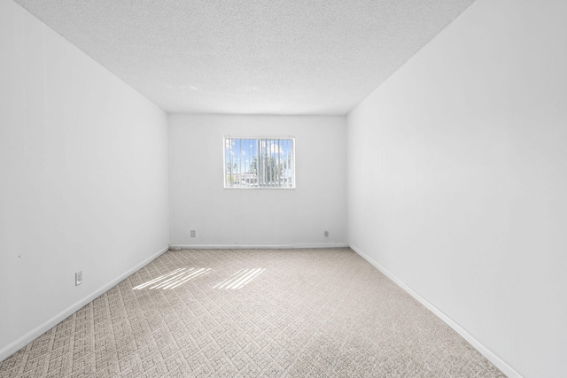 carpeted spare room featuring a textured ceiling