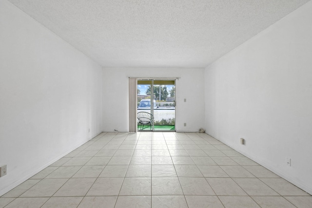 tiled spare room featuring a textured ceiling