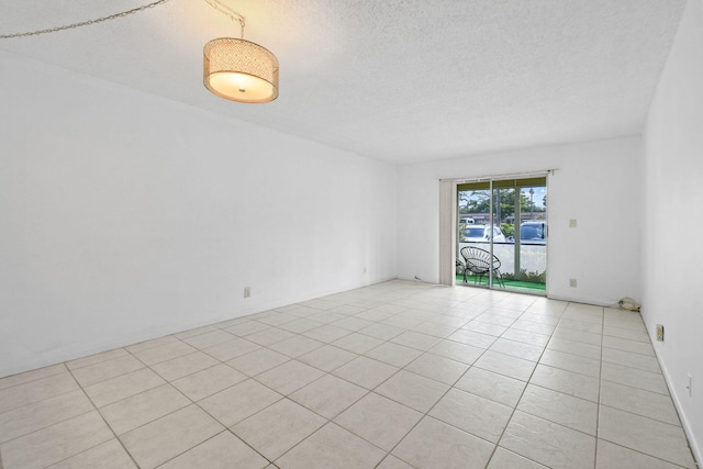 unfurnished room featuring a textured ceiling and light tile patterned flooring