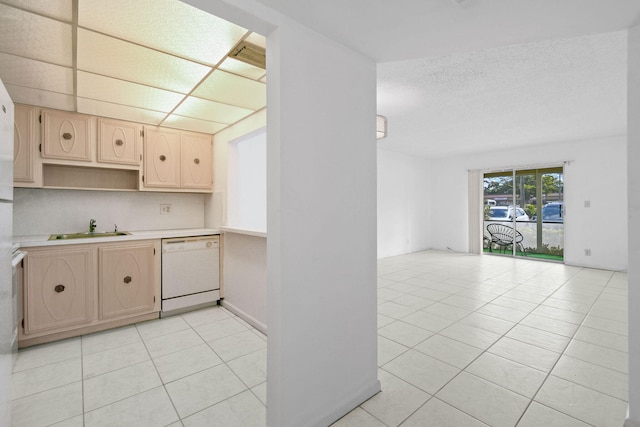 kitchen featuring white dishwasher, light brown cabinetry, light tile patterned floors, and sink