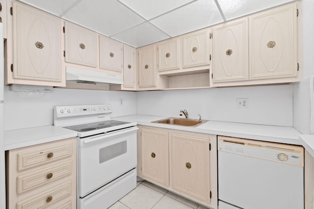 kitchen featuring a paneled ceiling, sink, white appliances, and light tile patterned floors