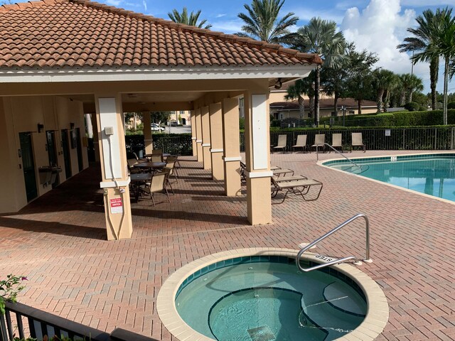 view of pool with a community hot tub and a patio