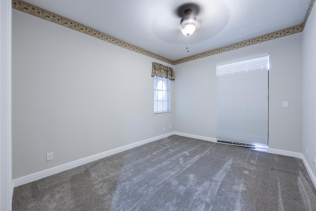 carpeted empty room featuring ceiling fan and a textured ceiling