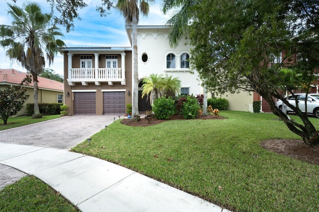 view of front of property with a front lawn, a garage, and a balcony