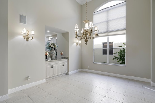 unfurnished dining area featuring plenty of natural light, light tile patterned floors, and a chandelier