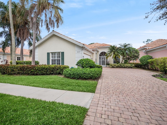 mediterranean / spanish home featuring a front lawn and a garage