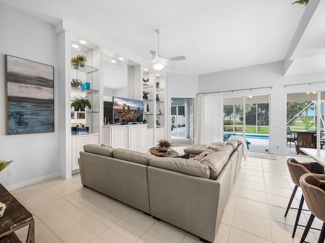 tiled living room with built in features and ceiling fan