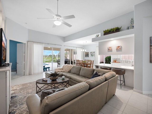 tiled living room with sink and ceiling fan with notable chandelier