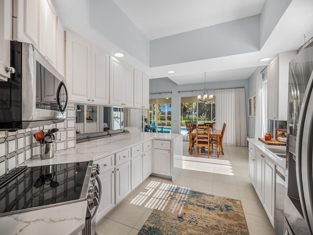 kitchen featuring white cabinetry, kitchen peninsula, appliances with stainless steel finishes, and light tile patterned floors