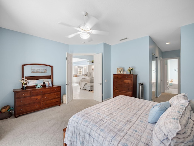 carpeted bedroom with ceiling fan and connected bathroom