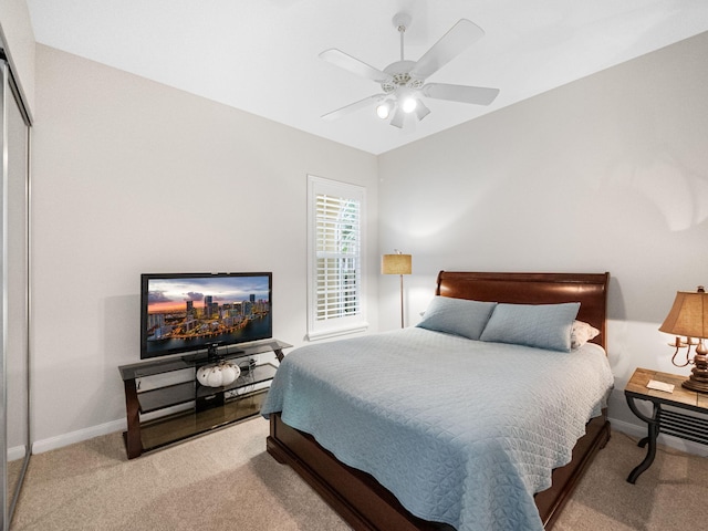 bedroom featuring ceiling fan, a closet, and light colored carpet