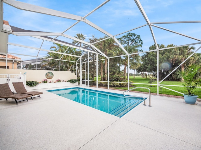 view of swimming pool featuring glass enclosure, a yard, and a patio