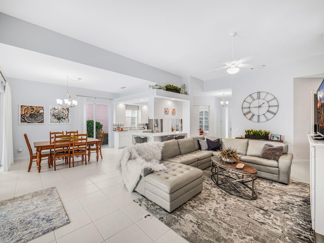 tiled living room with ceiling fan with notable chandelier