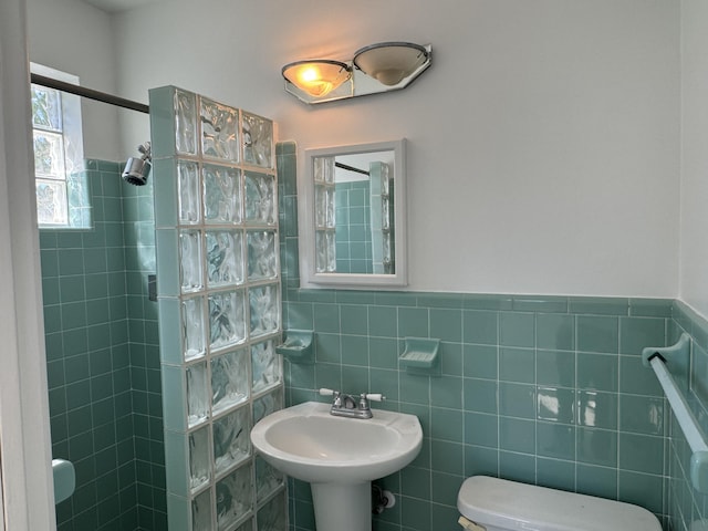 bathroom featuring toilet, tile walls, and tiled shower