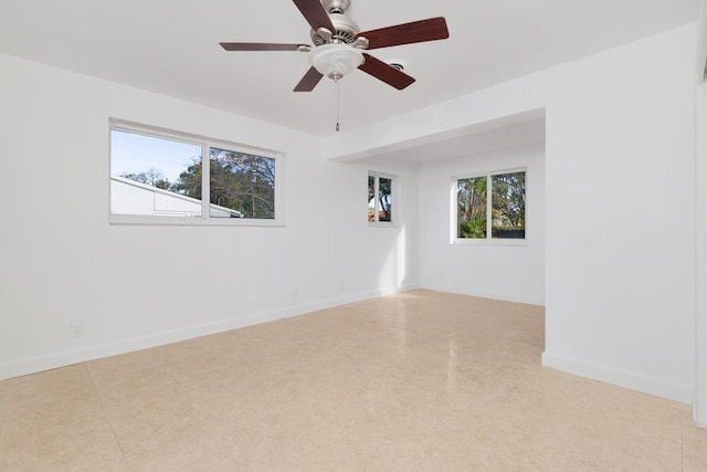 unfurnished room with ceiling fan and baseboards