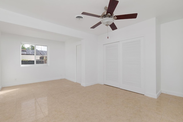 unfurnished bedroom featuring light tile patterned floors, a closet, visible vents, ceiling fan, and baseboards