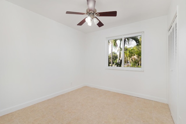 unfurnished room with a ceiling fan and baseboards