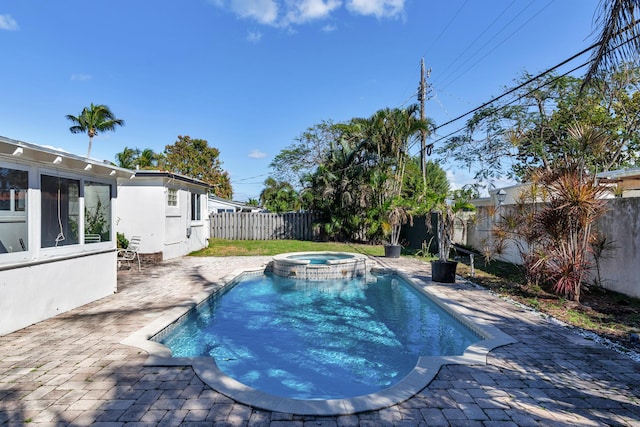 view of pool featuring a patio, a fenced backyard, and a pool with connected hot tub