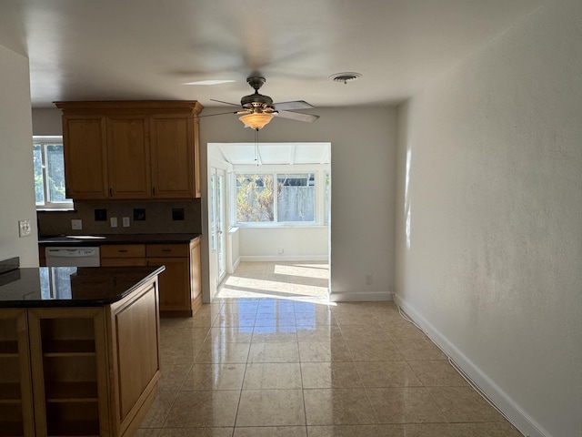 kitchen featuring backsplash, light tile patterned floors, ceiling fan, and white dishwasher