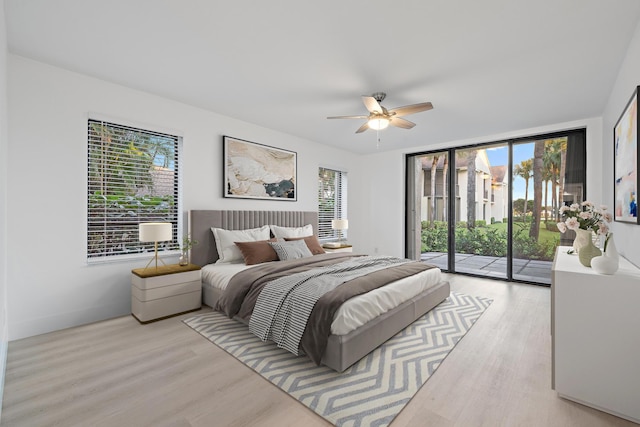 bedroom with access to exterior, a ceiling fan, baseboards, and wood finished floors