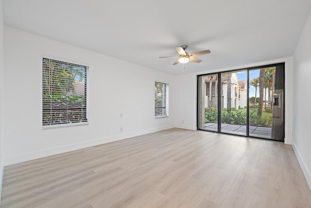 spare room with light wood-style floors, ceiling fan, and baseboards