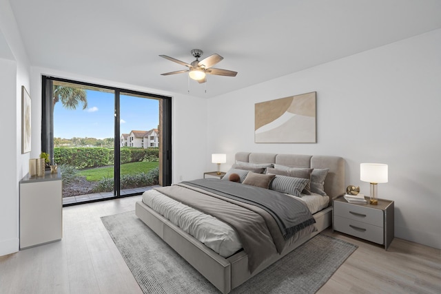 bedroom with a wall of windows, access to exterior, ceiling fan, and light wood finished floors