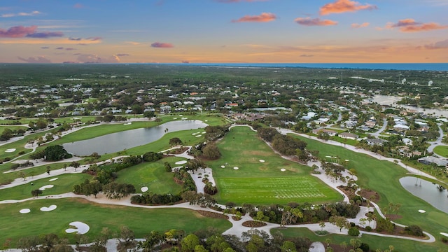 drone / aerial view featuring view of golf course and a water view