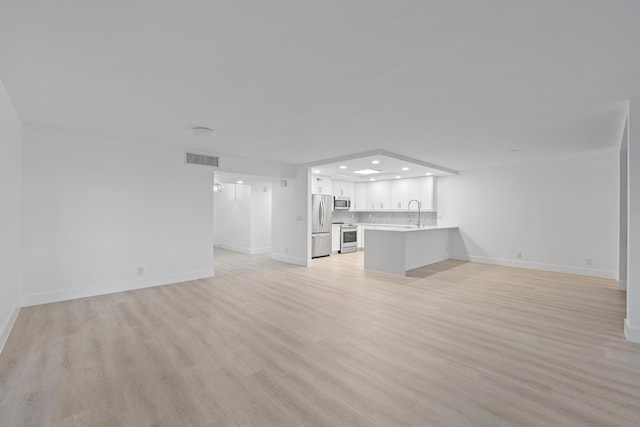 unfurnished living room featuring light hardwood / wood-style flooring and sink