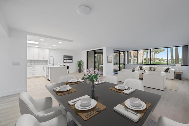 dining room featuring light wood-type flooring, plenty of natural light, baseboards, and recessed lighting