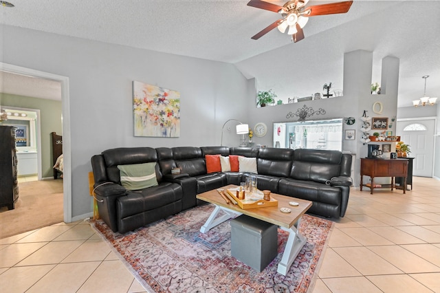 tiled living room with ceiling fan, a textured ceiling, and lofted ceiling