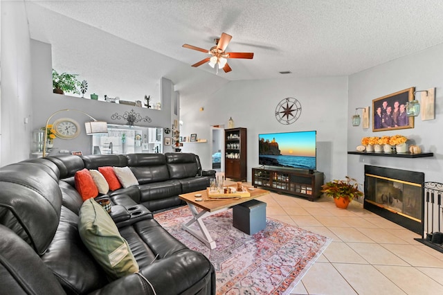 tiled living room with ceiling fan, a textured ceiling, and high vaulted ceiling