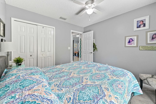 carpeted bedroom with a textured ceiling, a closet, and ceiling fan