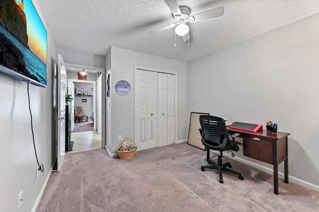 carpeted office featuring ceiling fan and a textured ceiling