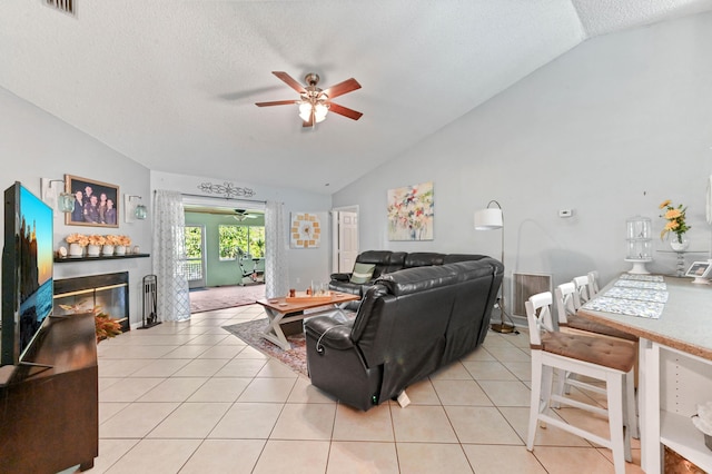 living room featuring light tile patterned floors, a textured ceiling, and vaulted ceiling