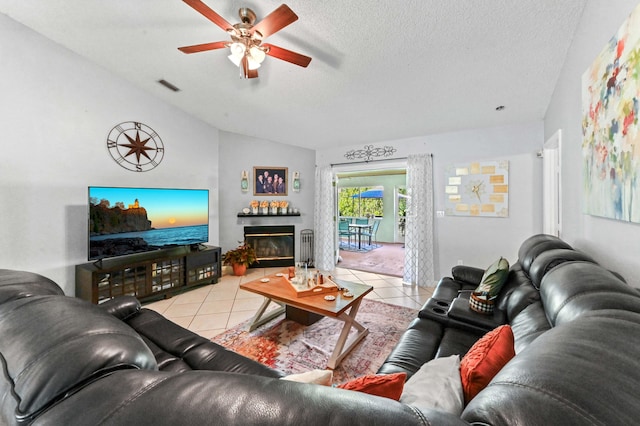 tiled living room featuring a textured ceiling, vaulted ceiling, and ceiling fan