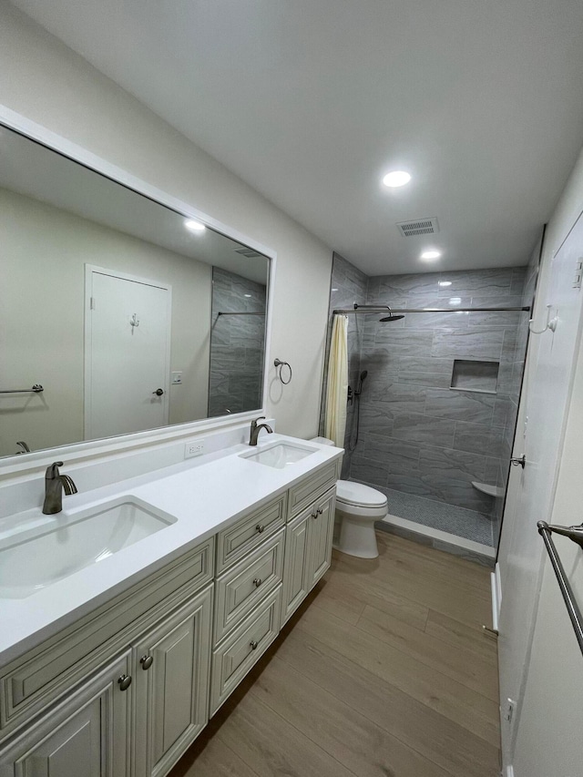 bathroom with a shower with shower curtain, wood-type flooring, vanity, and toilet