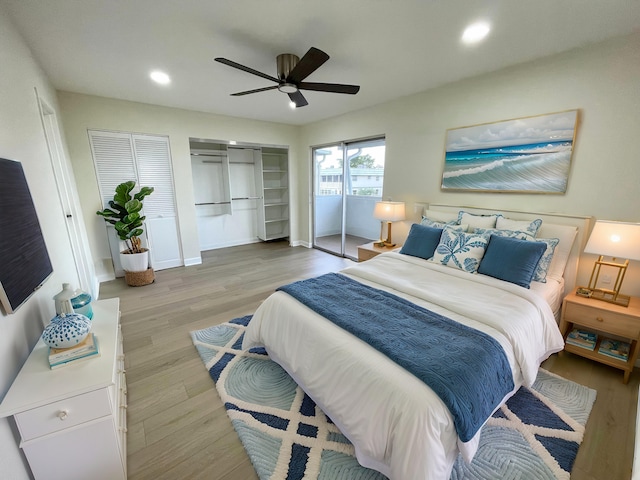 bedroom featuring two closets, light hardwood / wood-style flooring, and ceiling fan