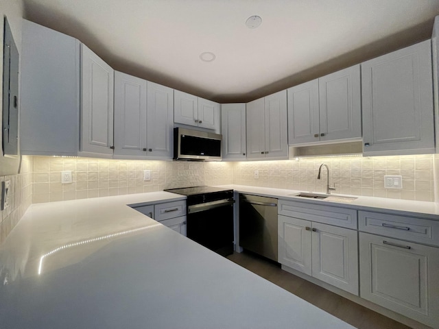 670 Monaco N Unit N, Delray Beach, FL 33446 - kitchen with stainless steel appliances, a sink, decorative backsplash, and light countertops